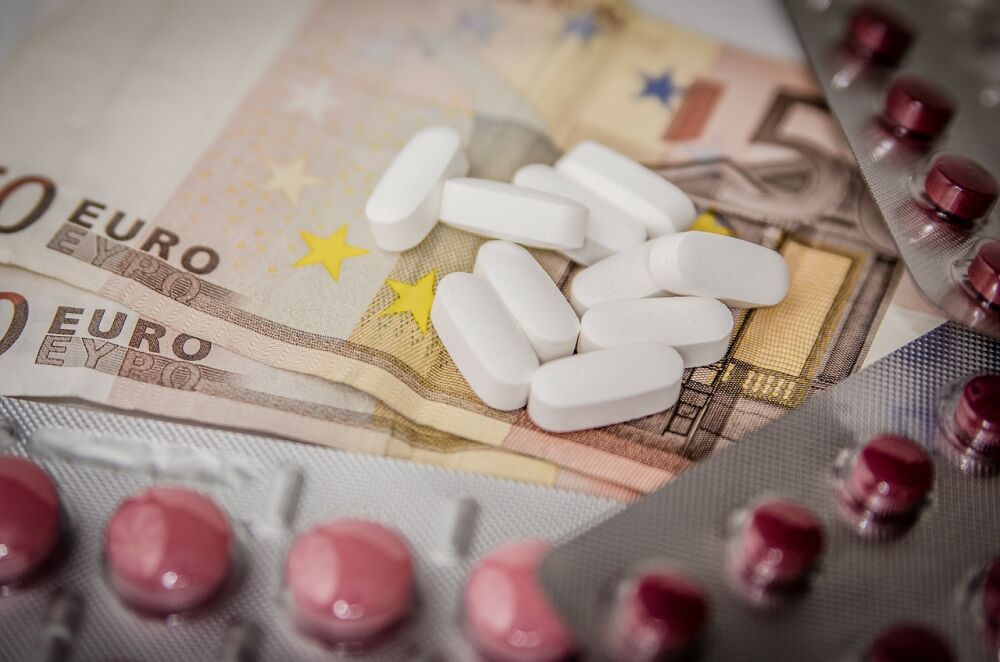 50 eurobiljetten omringd met medicijnen, symbolisch voor het verbeteren van het inkoopproces in de zorg